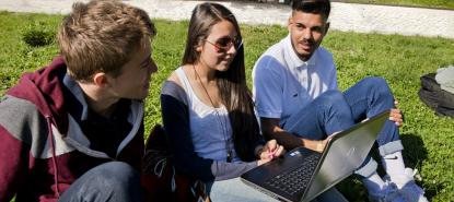 Groupe d'étudiants sur l'esplanade avec ordinateur